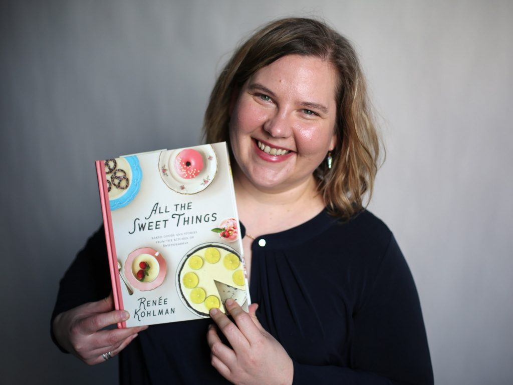 Renee Kohlman holds up her cookbook, All the Sweet Things