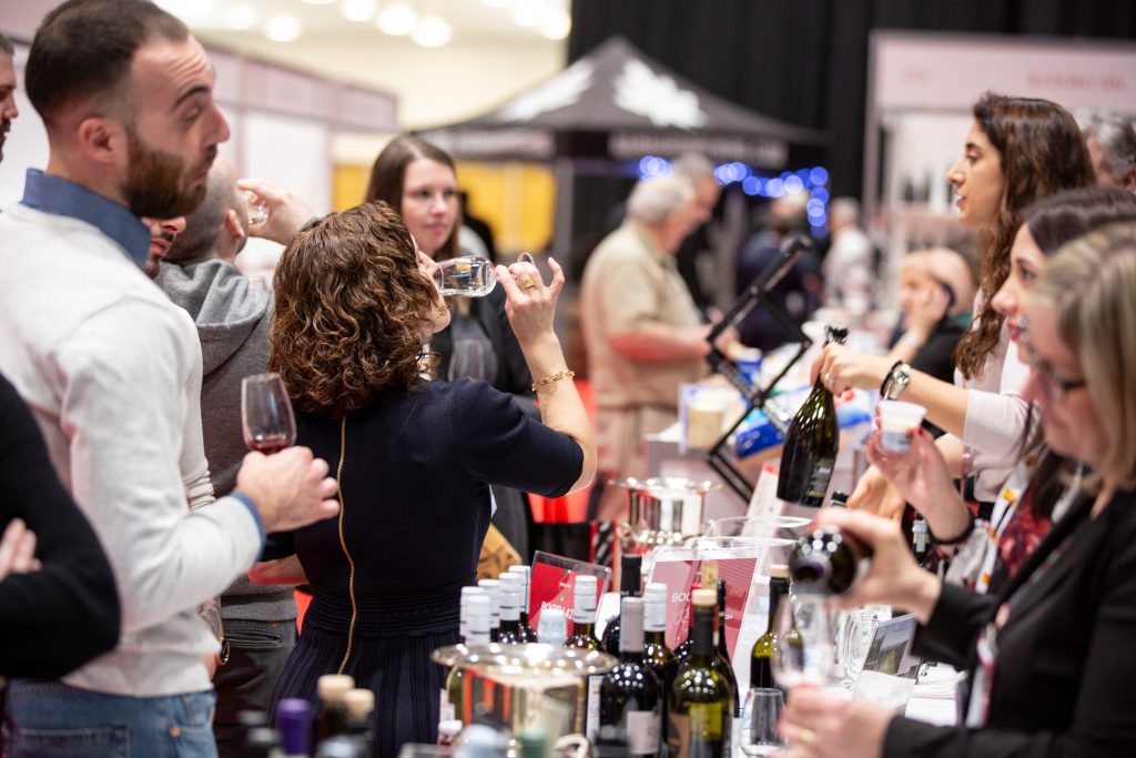 Trade show attendee tasting wine at a booth