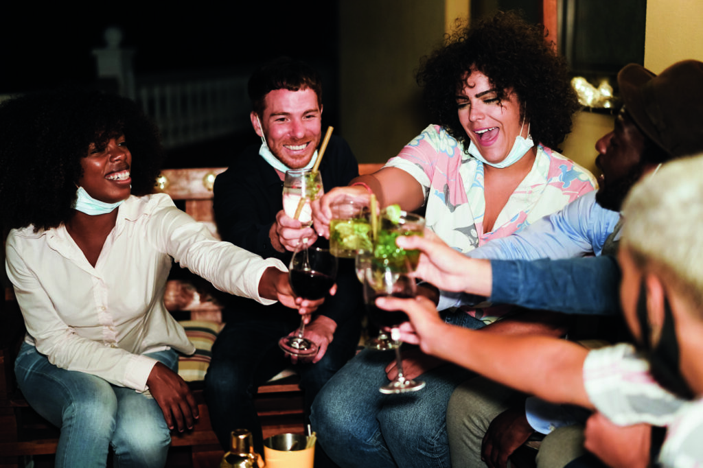 Happy multiracial people having fun drinking cocktails at terrace party during coronavirus outbreak.